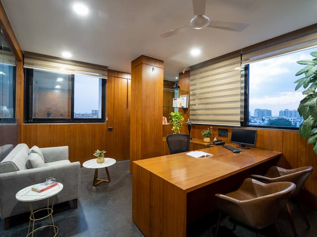 Nine o Six Advisory private cabin with a comfortable sofa, meeting table, and indoor plants, creating a professional and welcoming workspace.