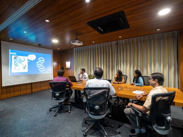 Team meeting in the conference room at Nine o Six Advisory with a professional presentation setup.