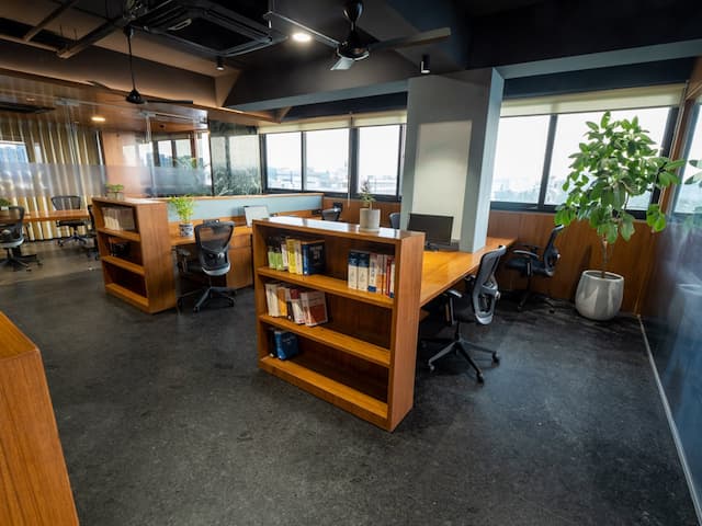 Nine o Six Advisory modern office workspace with ergonomic chairs, wooden interiors, and bookshelves.