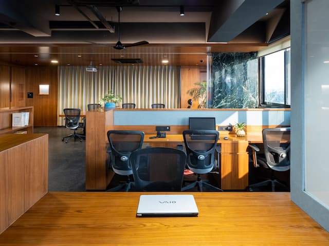 Nine o Six Advisory office desk setup with workstations, comfortable seating, and natural lighting.